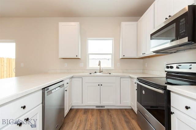 kitchen featuring sink, dark wood-type flooring, stainless steel appliances, and white cabinets