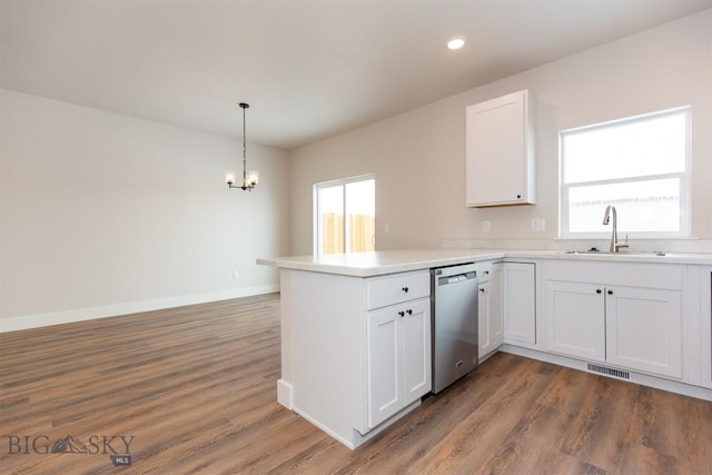 kitchen with sink, white cabinetry, hanging light fixtures, stainless steel dishwasher, and kitchen peninsula