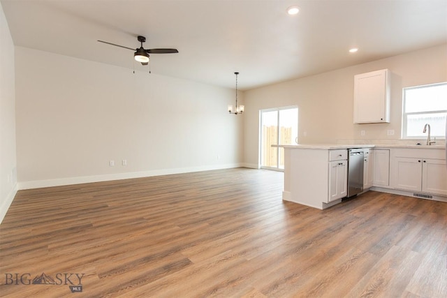 kitchen with dishwasher, kitchen peninsula, light hardwood / wood-style flooring, and white cabinets