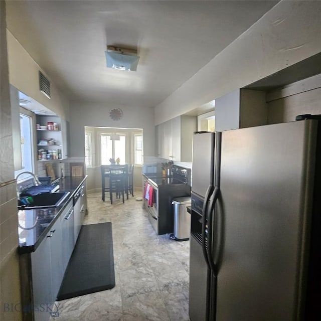 kitchen featuring sink, white cabinetry, stainless steel fridge, built in features, and electric stove