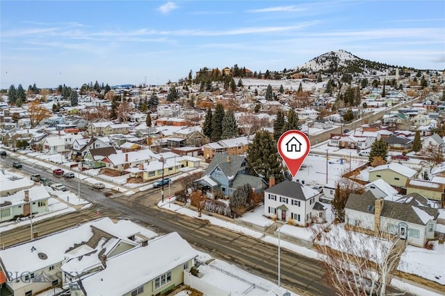 snowy aerial view with a residential view and a mountain view