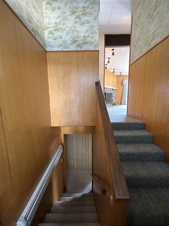 stairway featuring wood walls