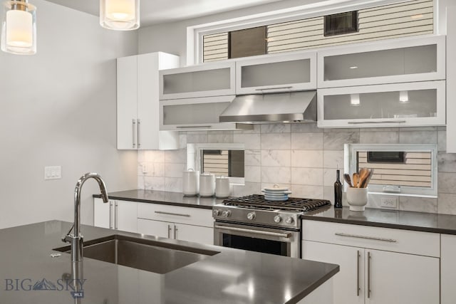 kitchen with white cabinets, decorative light fixtures, range hood, and stainless steel gas stove