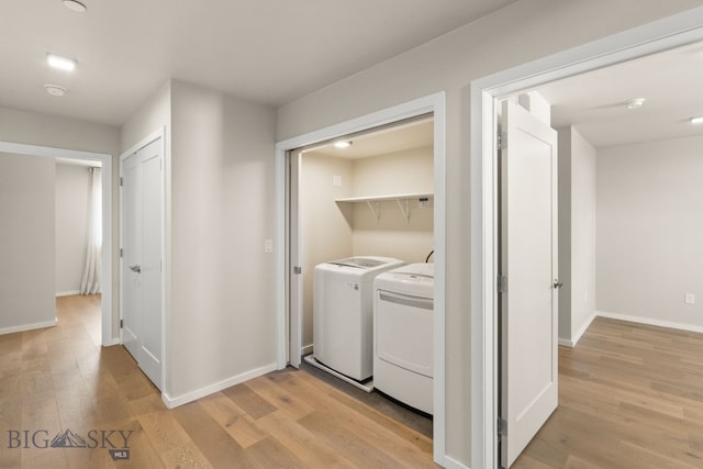 laundry area with washer and dryer and light wood-type flooring