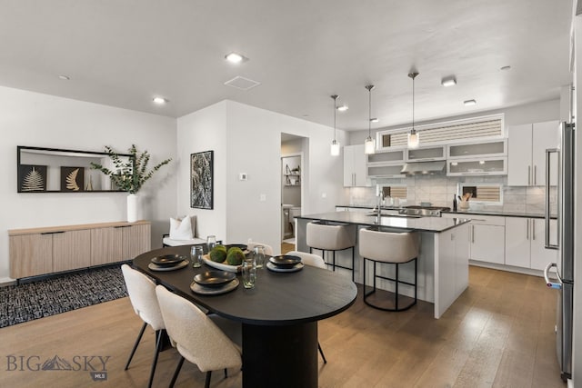 dining space with wood-type flooring and sink