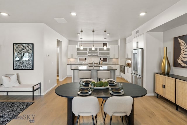 dining space with sink and light hardwood / wood-style floors