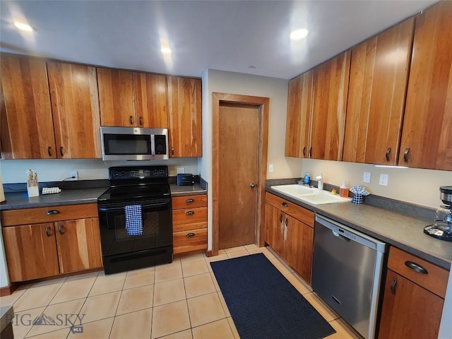 kitchen featuring stainless steel appliances, sink, and light tile patterned floors