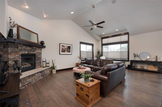 living room with dark wood-type flooring, ceiling fan, a fireplace, and vaulted ceiling