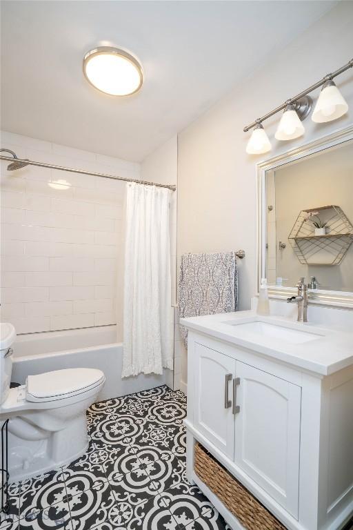 full bathroom with vanity, tile patterned floors, shower / bath combination with curtain, and toilet