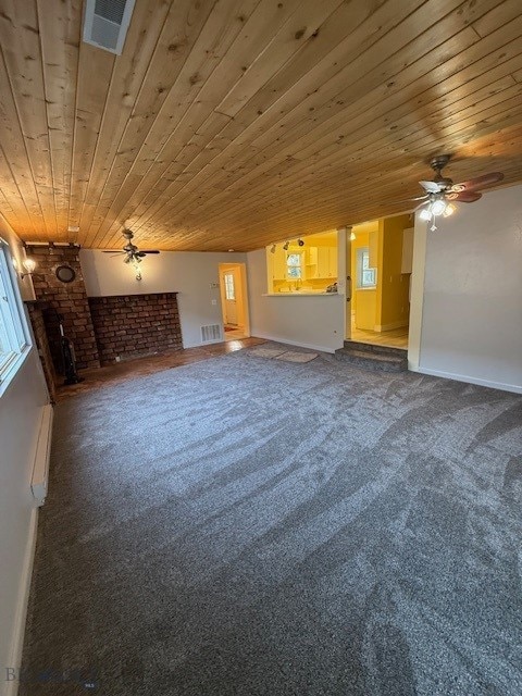 unfurnished living room with ceiling fan, carpet flooring, and wooden ceiling