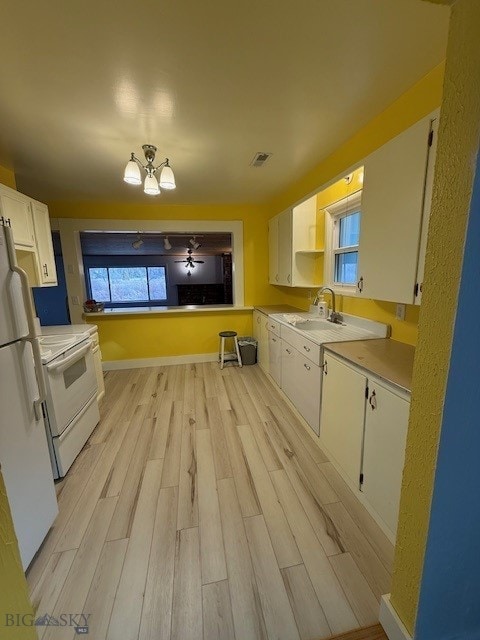 kitchen with white cabinetry, sink, a chandelier, white appliances, and light hardwood / wood-style flooring