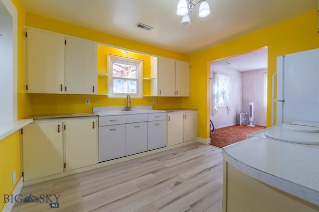 kitchen featuring sink, white fridge, and light hardwood / wood-style flooring