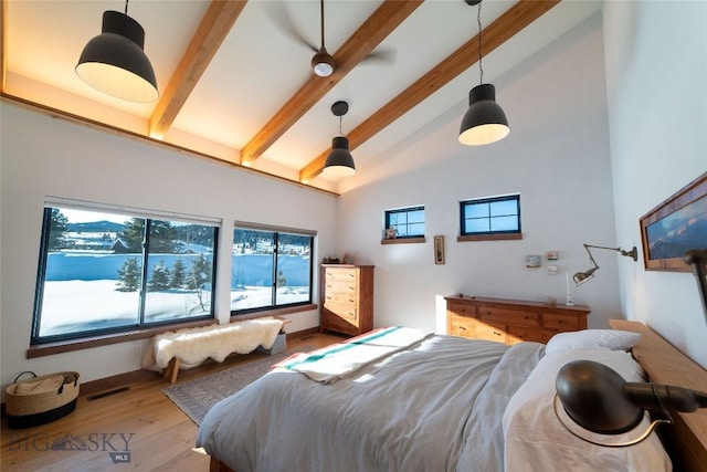 bedroom with beamed ceiling, high vaulted ceiling, and light hardwood / wood-style floors