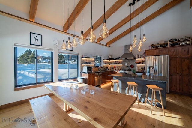 dining area featuring sink, beam ceiling, high vaulted ceiling, and light wood-type flooring