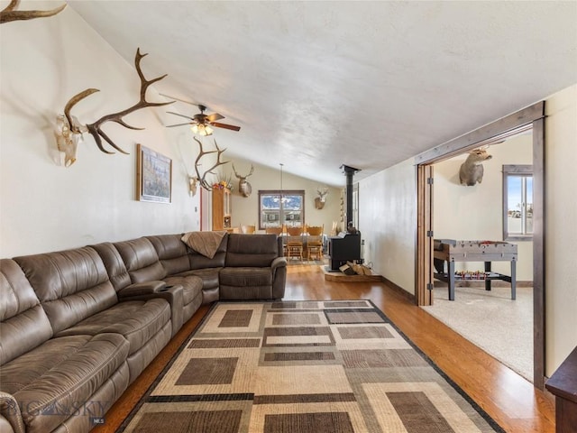 10 Fan Mountain Ct, Ennis, MT 59729 - living area featuring vaulted ceiling, a wood stove, wood finished floors, and a wealth of natural light