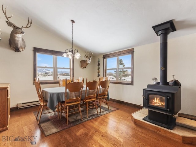 10 Fan Mountain Ct, Ennis, MT 59729 - dining area featuring a wood stove, baseboards, wood finished floors, lofted ceiling, and a baseboard radiator
