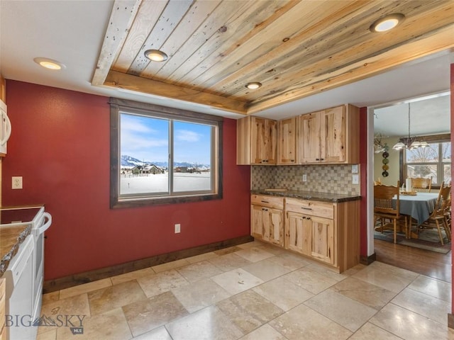 10 Fan Mountain Ct, Ennis, MT 59729 - kitchen featuring dark countertops, range, baseboards, tasteful backsplash, and a tray ceiling