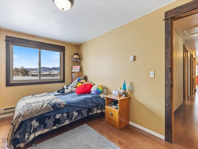 10 Fan Mountain Ct, Ennis, MT 59729 - bedroom featuring baseboard heating, baseboards, and wood finished floors