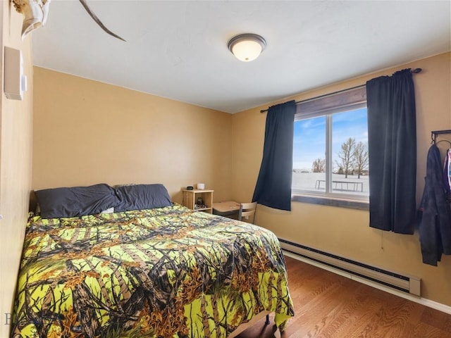 10 Fan Mountain Ct, Ennis, MT 59729 - bedroom with baseboards, a baseboard heating unit, and wood finished floors