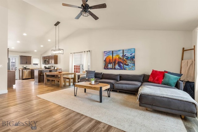 living room with ceiling fan, high vaulted ceiling, and light hardwood / wood-style flooring