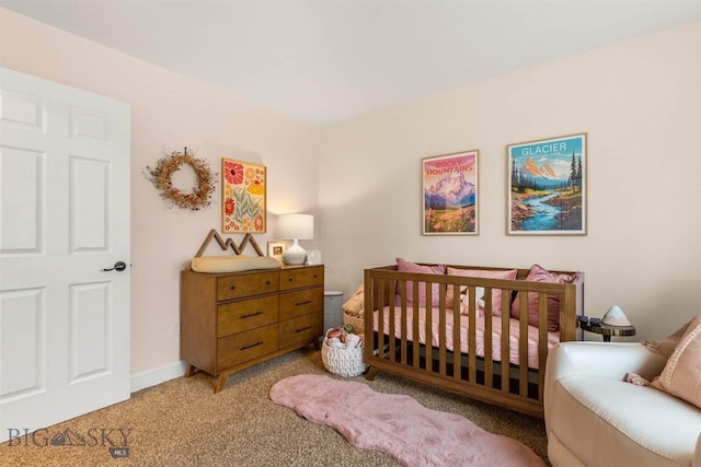 bedroom with a nursery area and carpet