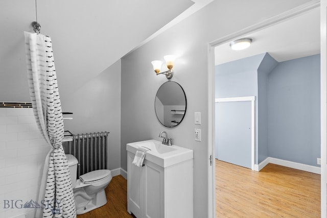 bathroom with vanity, toilet, radiator, and hardwood / wood-style floors