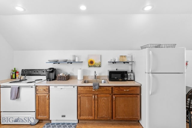 kitchen with light hardwood / wood-style flooring, sink, white appliances, and vaulted ceiling