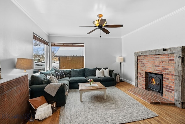 living room featuring crown molding, a brick fireplace, hardwood / wood-style floors, and ceiling fan