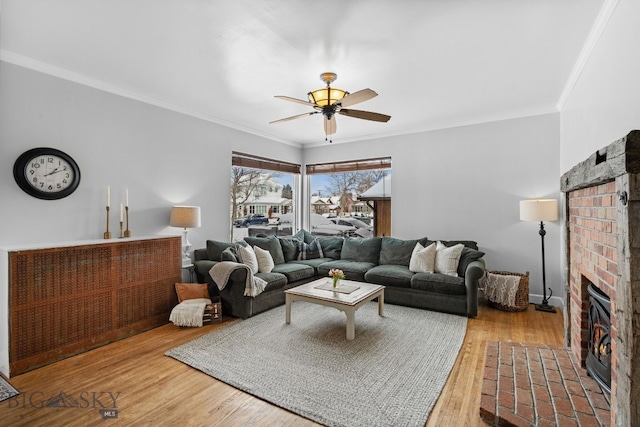 living room with crown molding, hardwood / wood-style floors, and a fireplace