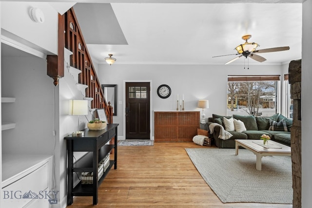 living room featuring crown molding, ceiling fan, and light wood-type flooring