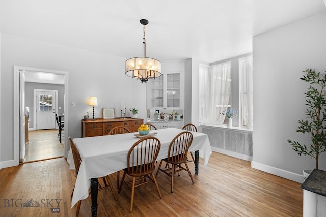 dining space with sink, a chandelier, and light hardwood / wood-style floors