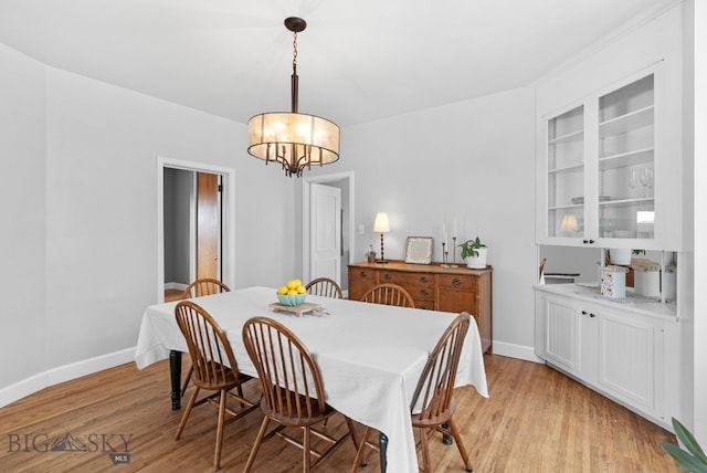 dining space featuring an inviting chandelier and light hardwood / wood-style flooring