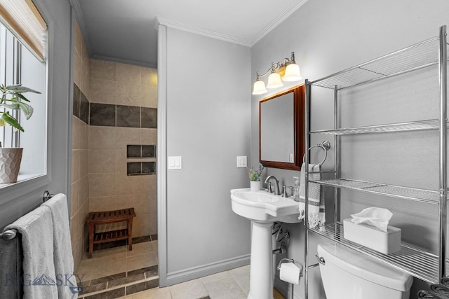 bathroom with tiled shower, ornamental molding, toilet, and tile patterned floors