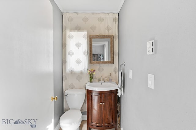 bathroom with crown molding, vanity, and toilet