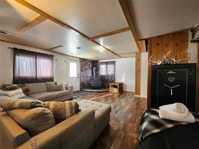 living room featuring a wood stove, beamed ceiling, and dark hardwood / wood-style floors