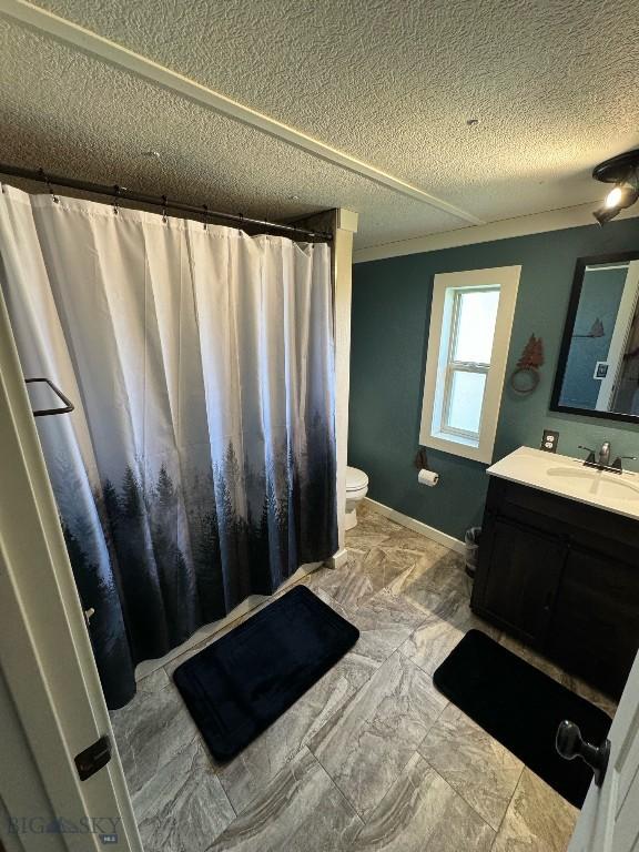 bathroom featuring toilet, a textured ceiling, and vanity