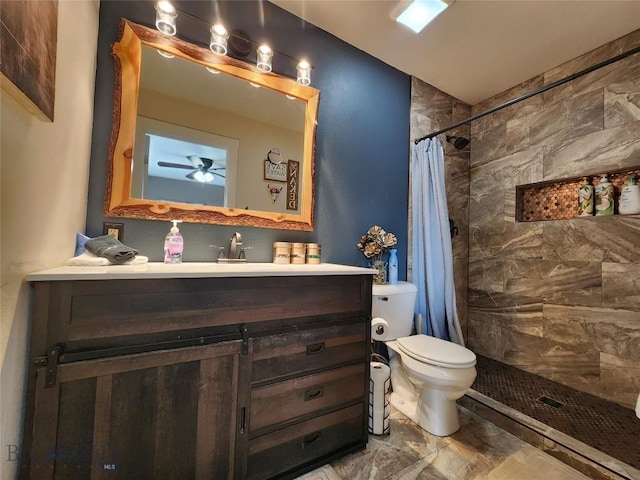 bathroom featuring toilet, vanity, walk in shower, and ceiling fan