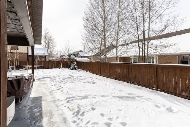 yard layered in snow with a trampoline