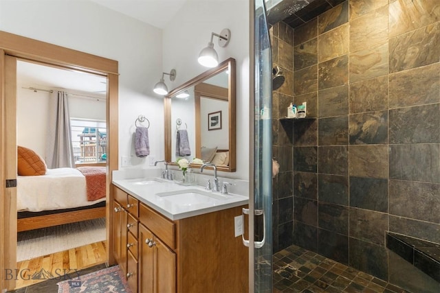 bathroom with hardwood / wood-style floors, a tile shower, and vanity