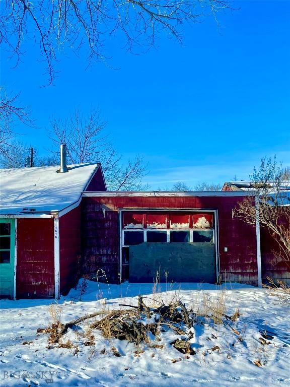 view of snow covered exterior featuring an outbuilding