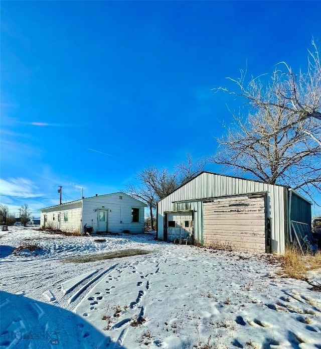 snow covered structure featuring a garage