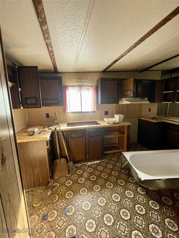 kitchen featuring a textured ceiling, light countertops, and tile patterned floors