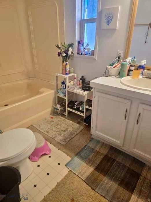 bathroom featuring toilet, shower / bathing tub combination, and vanity