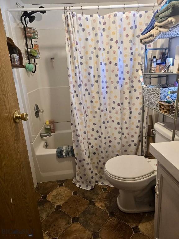 bathroom featuring vanity, toilet, and shower / bathtub combination with curtain