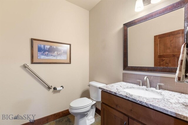 bathroom with tasteful backsplash, vanity, and toilet