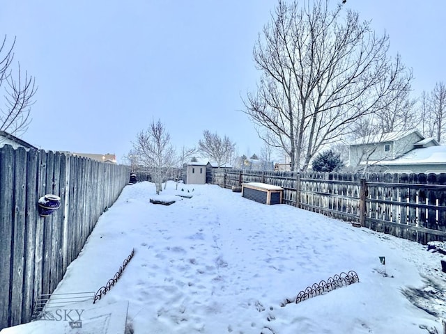 yard covered in snow featuring a shed