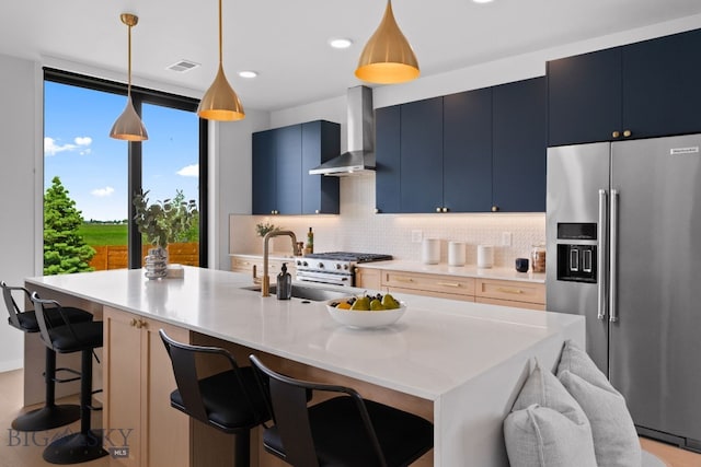 3057 S 31st Ave, Bozeman, MT 59718 - kitchen featuring high end appliances, wall chimney exhaust hood, backsplash, blue cabinetry, and light countertops