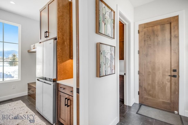 hall featuring dark tile patterned flooring