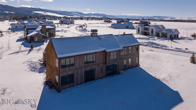 snowy aerial view featuring a mountain view