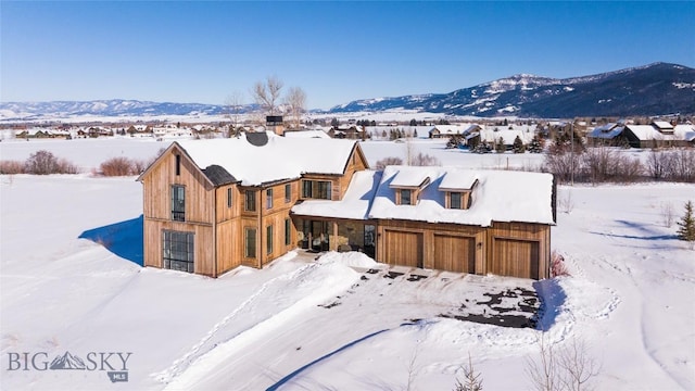 snowy aerial view featuring a mountain view